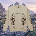 Beige sweatshirt with decorative boot stitch patterns on a scenic western background of mountains and flowers.