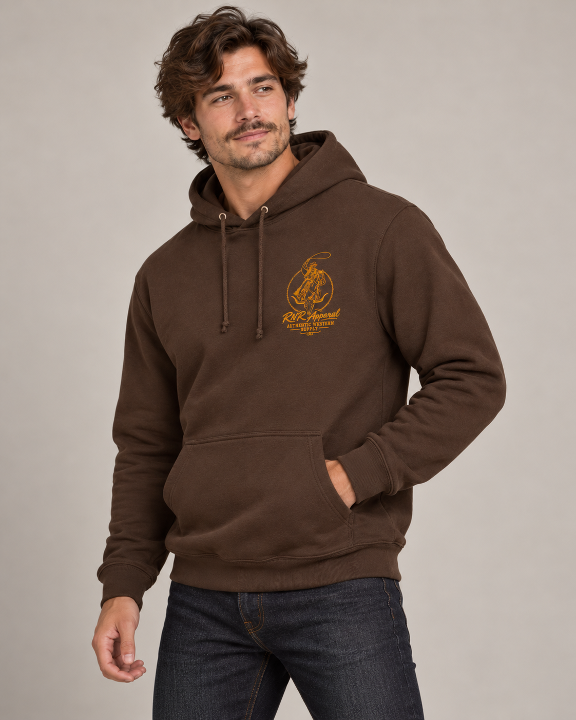 A man wearing a brown pullover hoodie with a large Orange graphic print on the back, shown from behind against a plain light gray studio background. cowboy roping a bull 